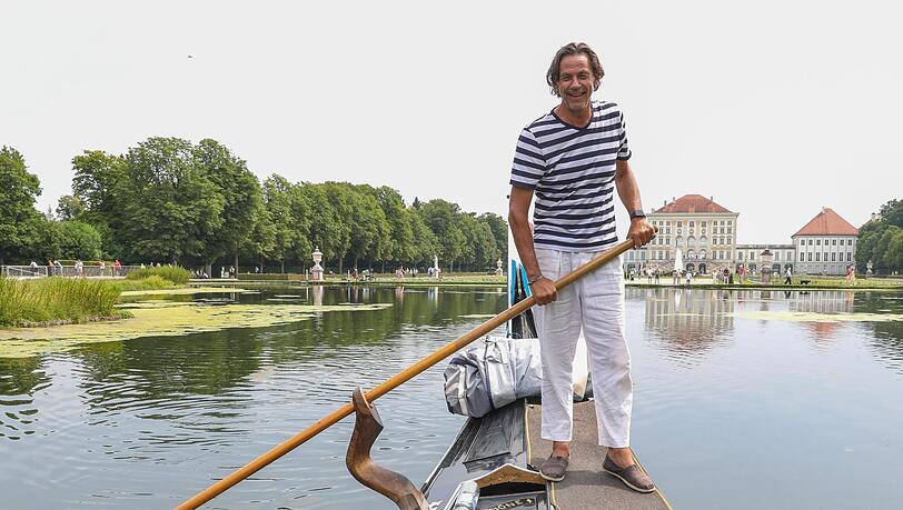Maximilian Koch am Ruder seiner Gondel vor der Kulisse von Schloss Nymphenburg. Das schwarz glänzende Gefährt, das wirklich aus Venedig kommt, ist elf Meter lang.