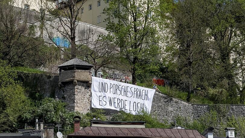 Ein Transparent mit der Aufschrift "Und Porsche sprach es werde Loch" hängt am Kapuzinerberg. In Salzburg demonstrierten Aktivisten gegen den geplanten Bau eines privaten Autotunnels von Wolfgang Porsche.