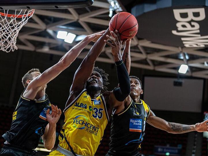 Landry Nnoko (M) von Alba Berlin setzt sich im Vorrundenspiel gegen zwei seiner Gegenspieler durch.