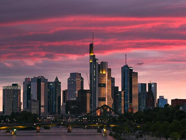 Bei Sonnenuntergang ist die Skyline der Bankenstadt in ein rötliches Licht getaucht.