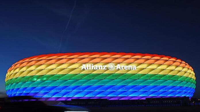 Die Hülle der Allianz Arena leuchtet in Regenbogenfarben.
