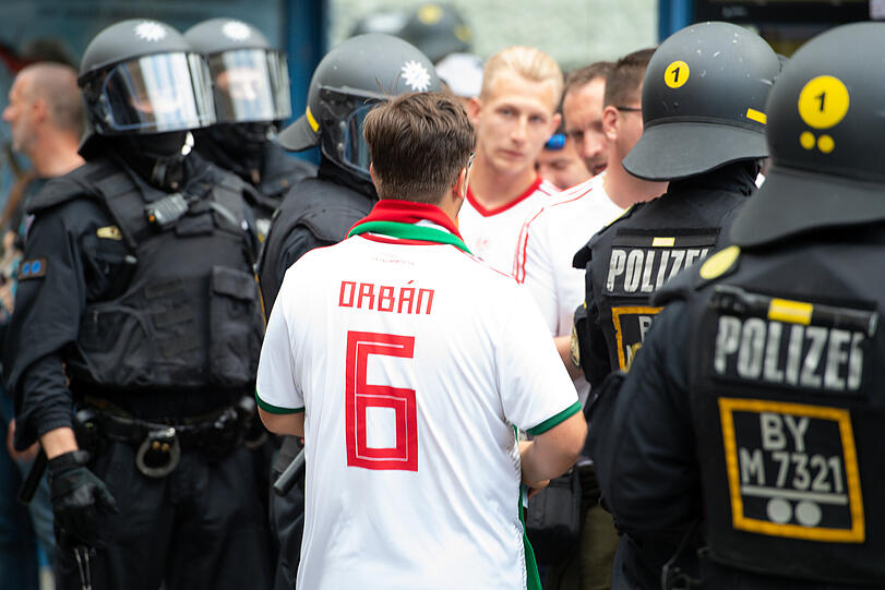 Ein ungarischer Fan bahnt sich den Weg durch Polizisten am Wiener Platz.