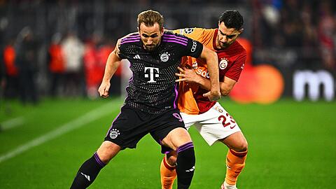 Bayern Münchens Harry Kane (l) und Galatasarays Kaan Ayhan kämpfen um den Ball.