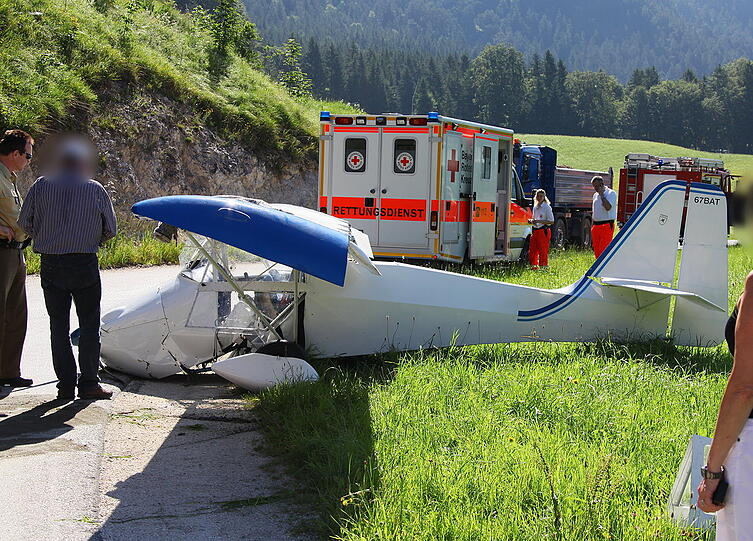 Ein notgelandetes Ultraleichtflugzeug liegt am Dienstag am Boden neben der Bundesstraße 20 bei Winkl im Landkreis Berchtesgaden. Der 59-jährige Pilot mußte am Morgen nach einem Triebwerksausfall notlanden - er und sein Fluggast kamen nach ersten Angaben des Rettungsdienstes nahezu unverletzt davon.