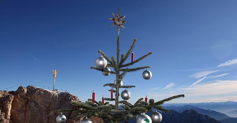 Bei traumhaftem, jedoch wenig weihnachtlichem Wetter, wird der Christbaum auf der Zugspitze präsentiert.