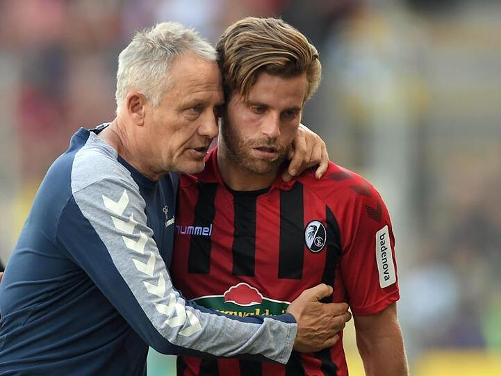 Freiburgs Trainer Christian Streich (l) tröstet den Torschützen Lucas Höler (r) nach seiner Auswechslung.