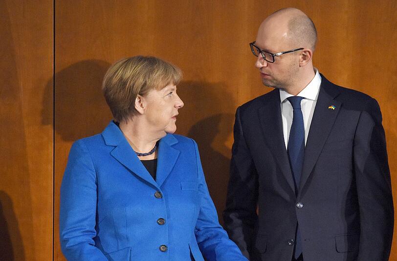 Der ukrainische Ministerpräsident Jazenjuk Kanzlerin Merkel unterhalten sich im Haus der Deutschen Wirtschaft in Berlin.
