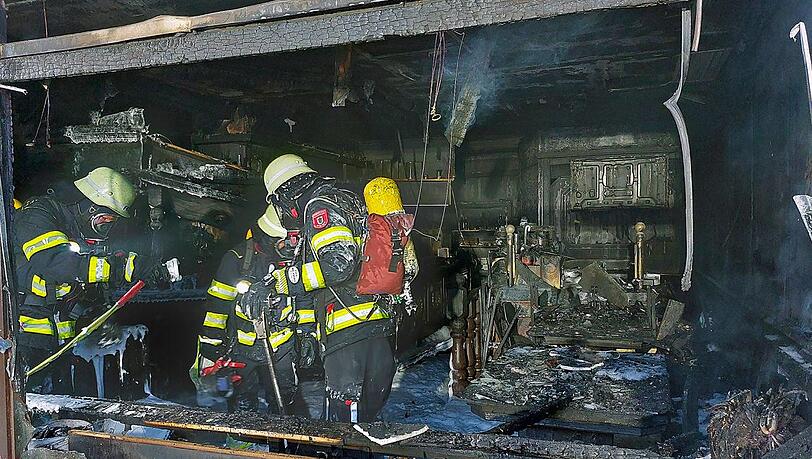 Feuerwehrleute stehen in dem völlig ausgebrannten China-Restaurant in der Freisinger Landstraße.