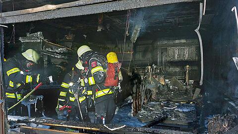Feuerwehrleute stehen in dem völlig ausgebrannten China-Restaurant in der Freisinger Landstraße.