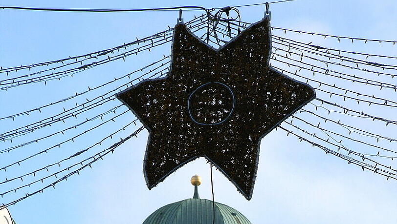 Der Stern über dem Eingang zum Christkindlmarkt in der Fußgängerzone, ist irgendwie aus der Form geraten. Der Stern über dem Eingang zum Christkindlmarkt in der Fußgängerzone, ist irgendwie aus der Form geraten.