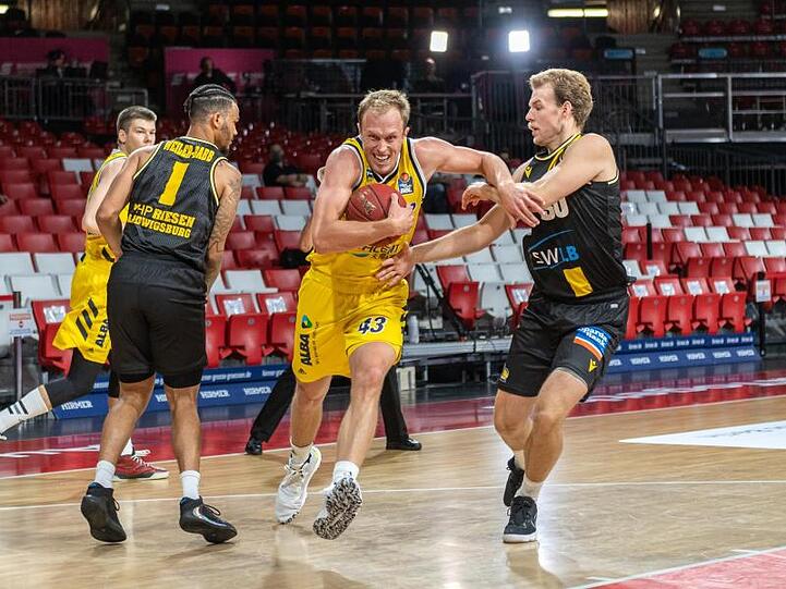 Luke Sikma von Alba Berlin (M) und Hans Brase (l) vom MHP Riesen Ludwigsburg kämpfen um den Ball. Foto: Tilo Wiedensohler/camera4/BBL/pool/dpa/Archivbild