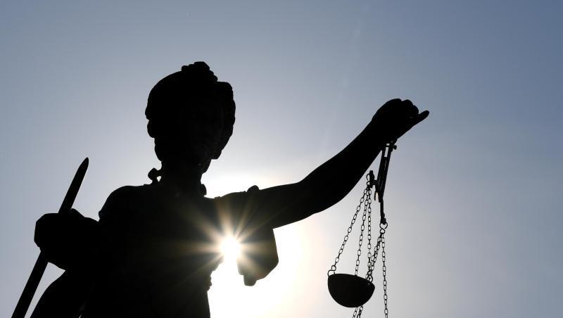 Die Statue der Justitia steht mit einer Waage und einem Schwert in der Hand.