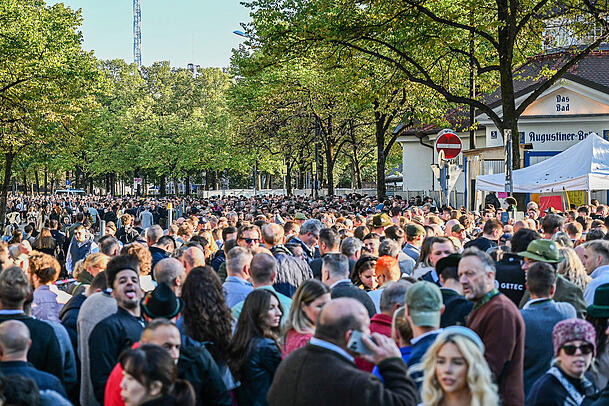Zahlreiche Besucher warten vor einem Eingang auf den Einlass zum Gelände des Oktoberfests. Zahlreiche Besucher warten vor einem Eingang auf den Einlass zum Gelände des Oktoberfests.