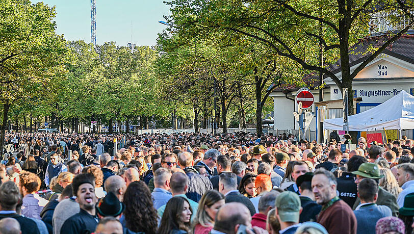 Zahlreiche Besucher warten vor einem Eingang auf den Einlass zum Gelände des Oktoberfests. Zahlreiche Besucher warten vor einem Eingang auf den Einlass zum Gelände des Oktoberfests.