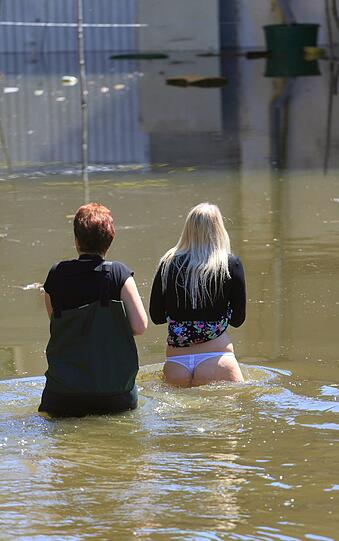 Als das Wasser tiefer wird, muss die junge Frau unfreiwillig Haut zeigen.