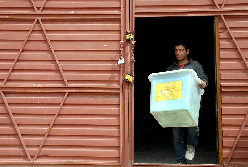 Die Wahlvorbereitungen sind im vollen Gange. Eine Afghane trägt die Kiste mit den Wahlzetteln zu den Wahlbehörden nach Mazar-e-Sharif. Afganistan wählt am 5. April einen neuen Präsidenten.