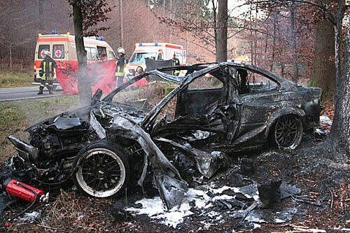 Völlig ausgebrannt ist das Auto, nachdem es gegen einen Baum prallte