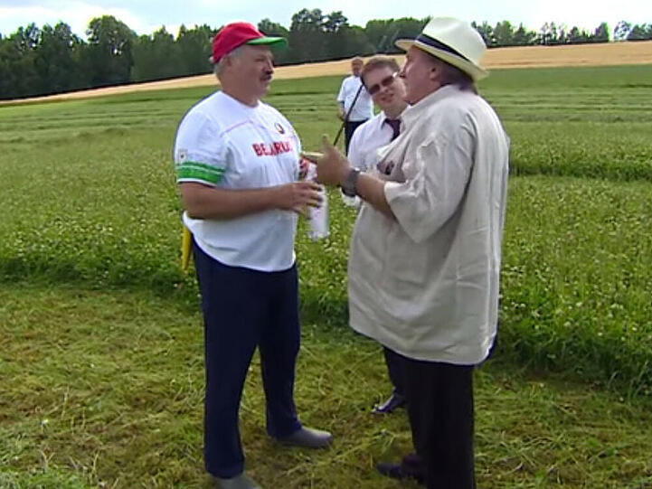 Der weißrussische Präsident Alexander Lukaschenko (l.) hat dem französischen Filmstar und Wahlrussen Gérard Depardieu beigebracht, wie man Gras auf einer Wiese mit einer Sense mäht