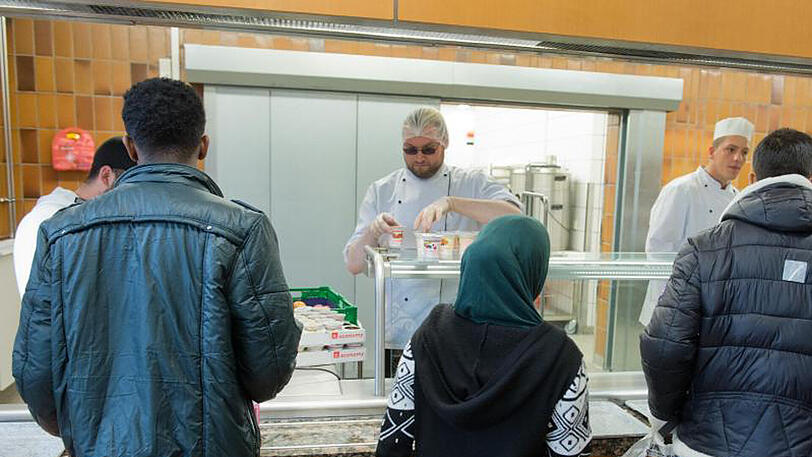 In der Essensausgabe erhalten Flüchtlinge ihr Mittagessen.