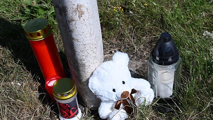 Menschen haben Kerzen und einen Teddybären an der Unfallstelle abgestellt.