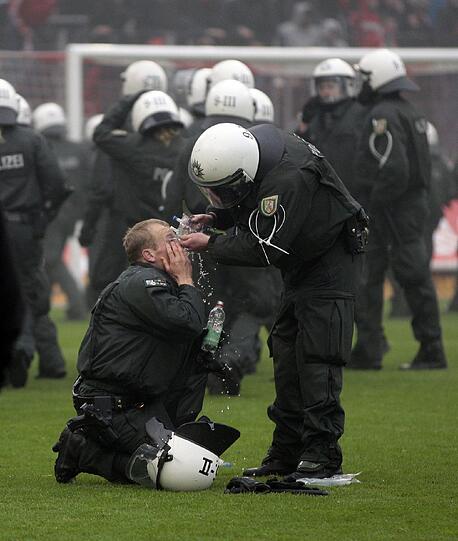 05.05.2012 Mit dem Schlusspfiff stürmen Hooligans des 1. FC Köln nach der 1:4-Niederlage gegen Bayern München den Platz und können nur von einem massiven Polizeiaufgebot in Schach gehalten werden. Zuvor waren bereits auf der Kölner Fantribüne Rauchbomben und Bengalische Feuer gezündet worden.
