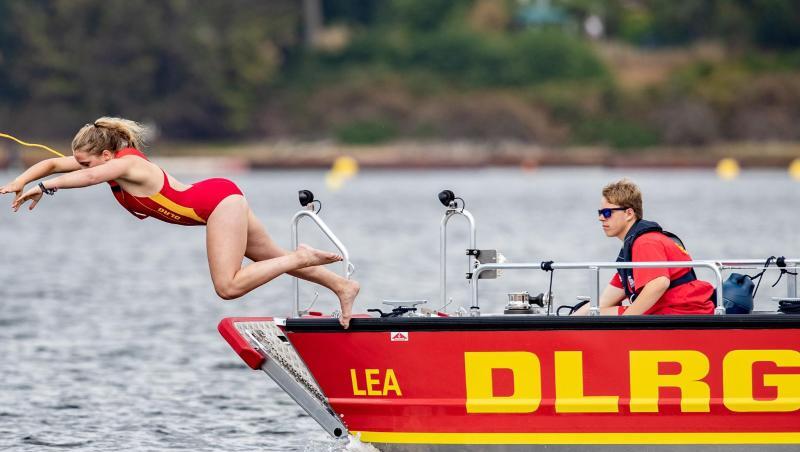 Eine Rettungsschwimmerin der DLRG springt in einen See. Foto: Marcel Kusch/dpa/Symbolbild