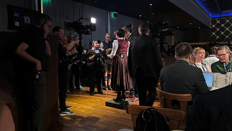 Wie die AZ beobachtet, schummelt sich BR-Moderatorin Ursula Heller mit einem Schemel etwas gr&ouml;&szlig;er.