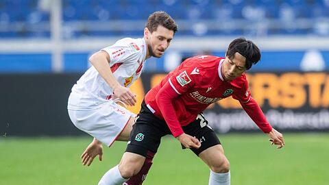 Hannovers Sei Muroya (r) und Regensburgs Charalambos Makridis kämpfen um den Ball.