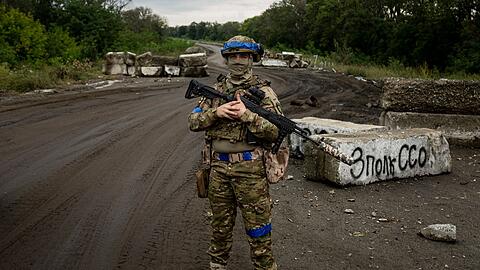Ein ukrainischer Soldat steht an einem Kontrollpunkt nahe des kürzlich zurückeroberten Gebiets von Isjum.