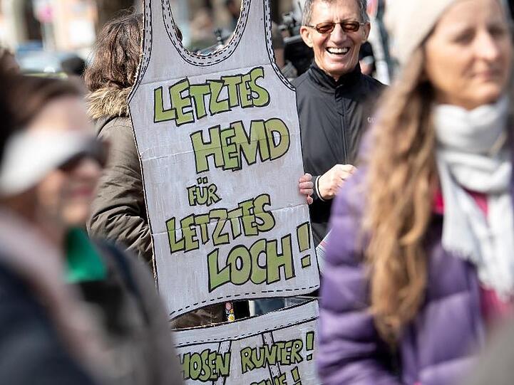 Eine Demonstrantin bringt es in München auf den Punkt: "Letztes Hemd für letztes Loch!"