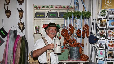 Sepp Stückl von den &bdquo;Schwuhplattlern&ldquo; im Souvenirgeschäft im Herzkasperlzelt.