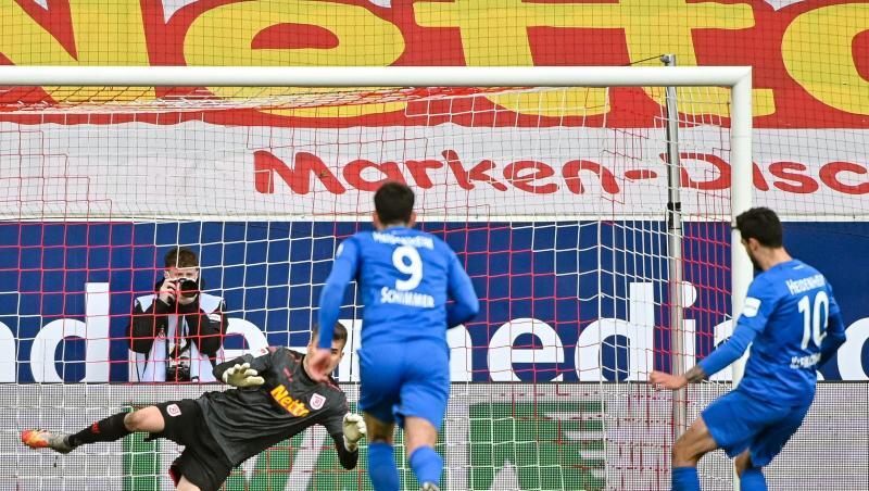 Tim Kleindienst von Heidenheim (r) trifft zum 0:3 gegen den Regensburger Torwart Alexander Meyer (2.v.l.).