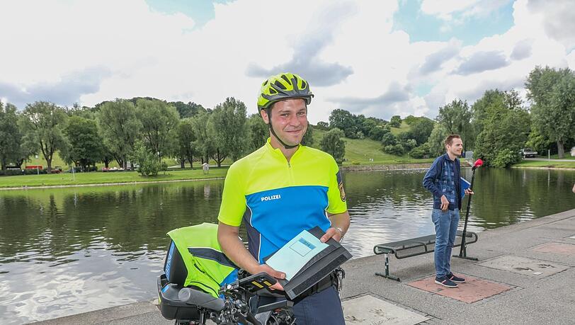 Polizeihauptkommissar Matthias Pötsch hält das Fahrtenbuch seines Dienstrades in Händen.