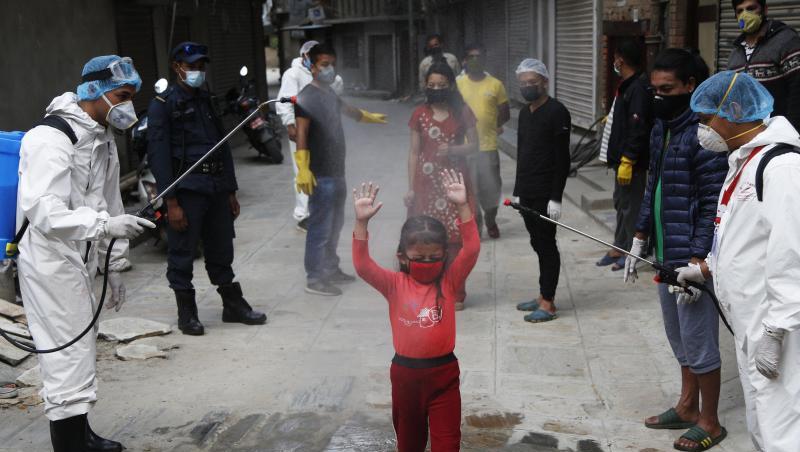 Ein Mädchen in Nepal wird mit Desinfektionsmittel besprüht. Ein Mädchen in Nepal wird mit Desinfektionsmittel besprüht.