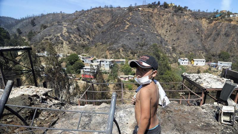 Ein Kind steht vor einem vom Feuer betroffenen Hügel in Valparaiso. Ein Kind steht vor einem vom Feuer betroffenen Hügel in Valparaiso.