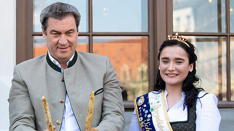 Markus Söder (CSU), Ministerpräsident von Bayern, und Annalena Fischhaber, Spargelkönigin von Bayern, stechen auf dem Viktualienmarkt symbolisch den ersten Spargel und eröffnen damit offiziell die Spargelsaison 2022.