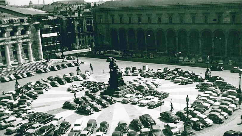 In Reih und Glied: 1956 lichtet Hans Gritsch die anständig abgestellten Autos auf dem Max-Joseph-Platz vor dem Nationaltheater ab. Anfang der
1960er-Jahre wird hier eine Tiefgarage gebaut – ohne große Rücksicht auf die untertägig erhaltenen Reste des Franziskanerklosters. In Reih und Glied: 1956 lichtet Hans Gritsch die anständig abgestellten Autos auf dem Max-Joseph-Platz vor dem Nationaltheater ab. Anfang der
1960er-Jahre wird hier eine Tiefgarage gebaut – ohne große Rücksicht auf die untertägig erhaltenen Reste des Franziskanerklosters.