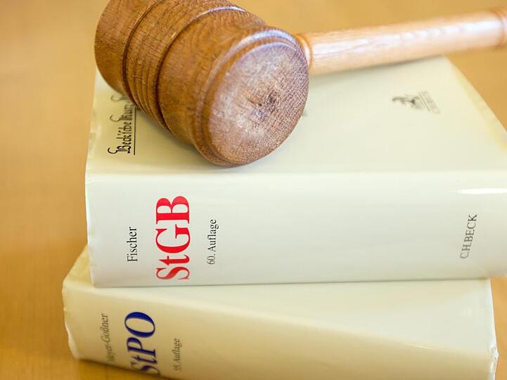 Ein Richterhammer und ein Strafgesetzbuch liegen auf einem Tisch. Foto: picture alliance / dpa