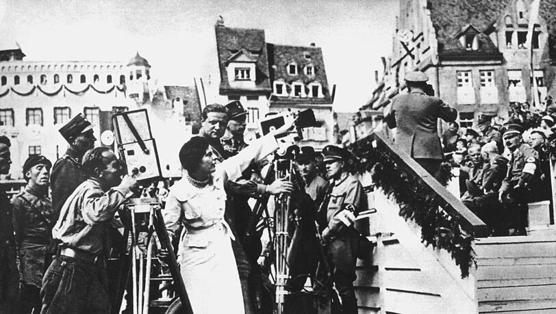 Das undatierte Archivbild zeigt Leni Riefenstahl (M), die Regieanweisungen für ihre Dokumentation des Nürnberger Parteitags 1934 gibt. Der Film "Triumph des Willens" wurde zum Schicksal der umstrittenen Regisseurin. Adolf Hitler persönlich gab ihr den Auftrag, ein "Filmkunstwerk" über den NS-Parteitag im September 1934 zu drehen. Bis heute streiten sich Filmhistoriker darüber, ob es einer der perfektesten Propagandafilme der Filmgeschichte ist oder oder tatsächlich ein neue Maßstäbe setzendes cineastisches Meisterwerk. dpa (zu dpa-Korr. "'Triumph des Willens' - Perfekte Propaganda oder Kultfilm" im Themenpaket Leni Riefenstahl am 14.08.2002 - nur sw) +++ dpa-Bildfunk +++ Das undatierte Archivbild zeigt Leni Riefenstahl (M), die Regieanweisungen für ihre Dokumentation des Nürnberger Parteitags 1934 gibt. Der Film "Triumph des Willens" wurde zum Schicksal der umstrittenen Regisseurin. Adolf Hitler persönlich gab ihr den Auftrag, ein "Filmkunstwerk" über den NS-Parteitag im September 1934 zu drehen. Bis heute streiten sich Filmhistoriker darüber, ob es einer der perfektesten Propagandafilme der Filmgeschichte ist oder oder tatsächlich ein neue Maßstäbe setzendes cineastisches Meisterwerk. dpa (zu dpa-Korr. "'Triumph des Willens' - Perfekte Propaganda oder Kultfilm" im Themenpaket Leni Riefenstahl am 14.08.2002 - nur sw) +++ dpa-Bildfunk +++