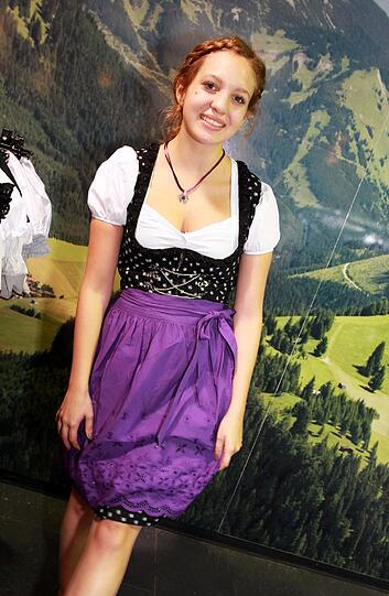 Alina zeigt das Dirndl von Almenrausch, das es mit einer Abendzeitung um 30 Prozent günstiger gibt. Wer kein lila mag, kann sich eine andere Schürze aussuchen.