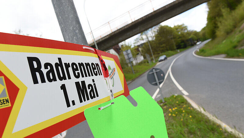 Ein Wegweiser mit der Aufschrift "Radrennen 1. Mai" ist an einem Kreisel in Oberursel an der Straße zum Sandplacken an einem Pfosten befestigt. Ein Wegweiser mit der Aufschrift "Radrennen 1. Mai" ist an einem Kreisel in Oberursel an der Straße zum Sandplacken an einem Pfosten befestigt.