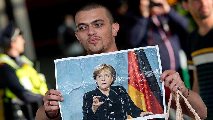 Ankunft mit der Kanzlerin in den Händen: Dieses Foto wurde zum Sinnbild für die Flüchtlingspolitik von Angela Merkel. In der CSU kommt ihr offener Kurs nicht gut an. Ankunft mit der Kanzlerin in den Händen: Dieses Foto wurde zum Sinnbild für die Flüchtlingspolitik von Angela Merkel. In der CSU kommt ihr offener Kurs nicht gut an.