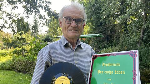 BN-Ortsvorsitzender Franz Meindl zeigt das Album mit der Musik von Hans Ristl.