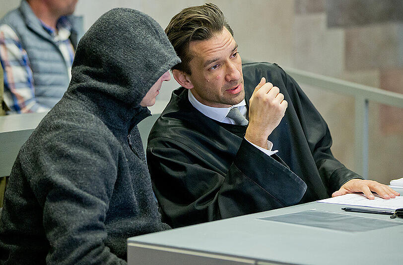 Der Beschuldigte Bernd G. (l) unterhält sich im Ansbacher Landgericht mit seinem Anwalt. Der 48-Jährige soll im Juli 2015 eine Frau und einen Mann aus einem Auto heraus erschossen haben. (Archivbild)