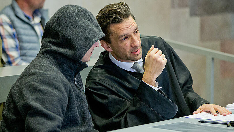 Der Beschuldigte Bernd G. (l) unterhält sich im Ansbacher Landgericht mit seinem Anwalt. Der 48-Jährige soll im Juli 2015 eine Frau und einen Mann aus einem Auto heraus erschossen haben. (Archivbild)