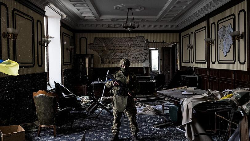 Ein ukrainischer Soldat steht inmitten von Trümmern in einem Büro im Gebäude der Regionalverwaltung von Charkiw.