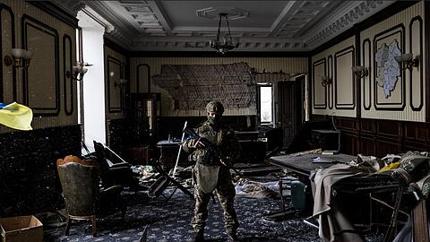 Ein ukrainischer Soldat steht inmitten von Trümmern in einem Büro im Gebäude der Regionalverwaltung von Charkiw.