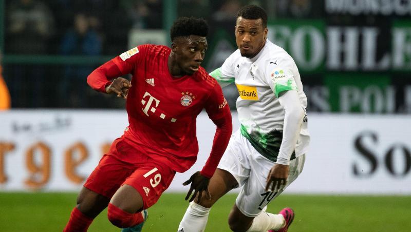 Bayerns Alphonso Davies und Mönchengladbachs Alassane Plea (l-r.) im Zweikampf um den Ball. Bayerns Alphonso Davies und Mönchengladbachs Alassane Plea (l-r.) im Zweikampf um den Ball.