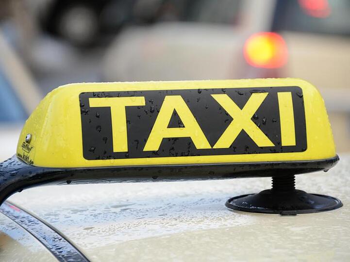 Ein Taxischild auf dem Dach eines Taxis. (Archivbild)