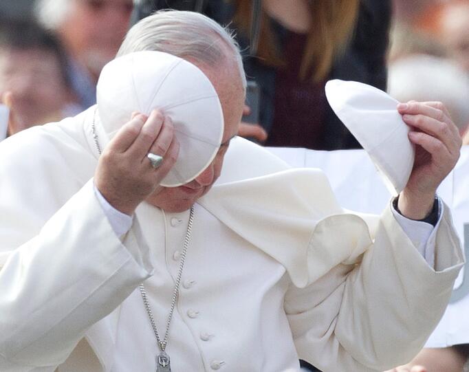 Papst Franziskus tauscht bei seiner wöchentlichen Ansprache am Petersplatz in Rom sein Pileolus gegen ein anderes aus, das ihm ein Gläubiger schenkte.